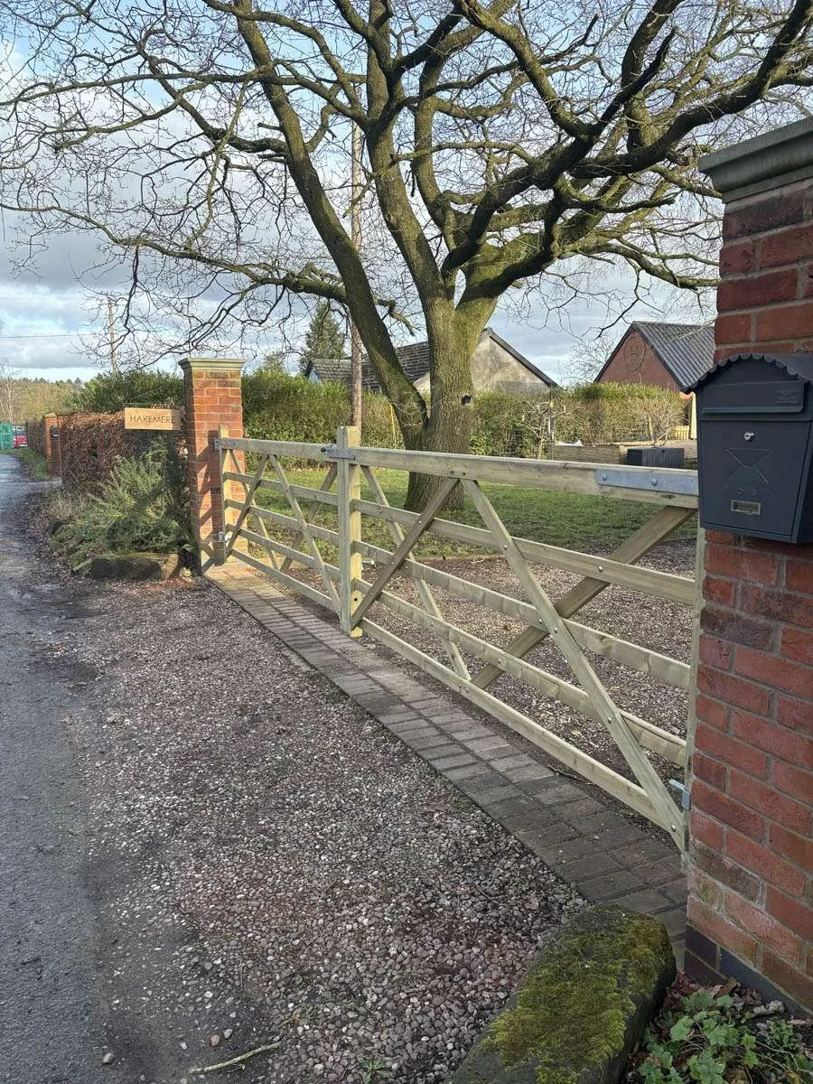 Five-bar timber gate across a gravel lane