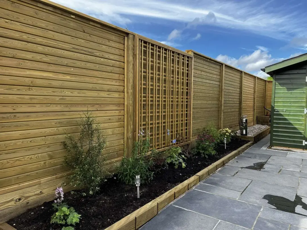 Slatted fence with trellis panels over a new patio